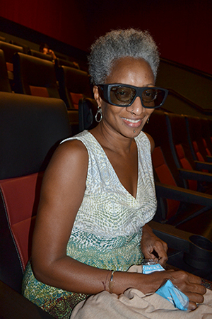 Cynthia Oliver, Associate Vice Chancellor for Research in the Humanities, Arts, and Related Fields, dons her 3D glasses in preparation for watching <em>A Beautiful Planet</em>.